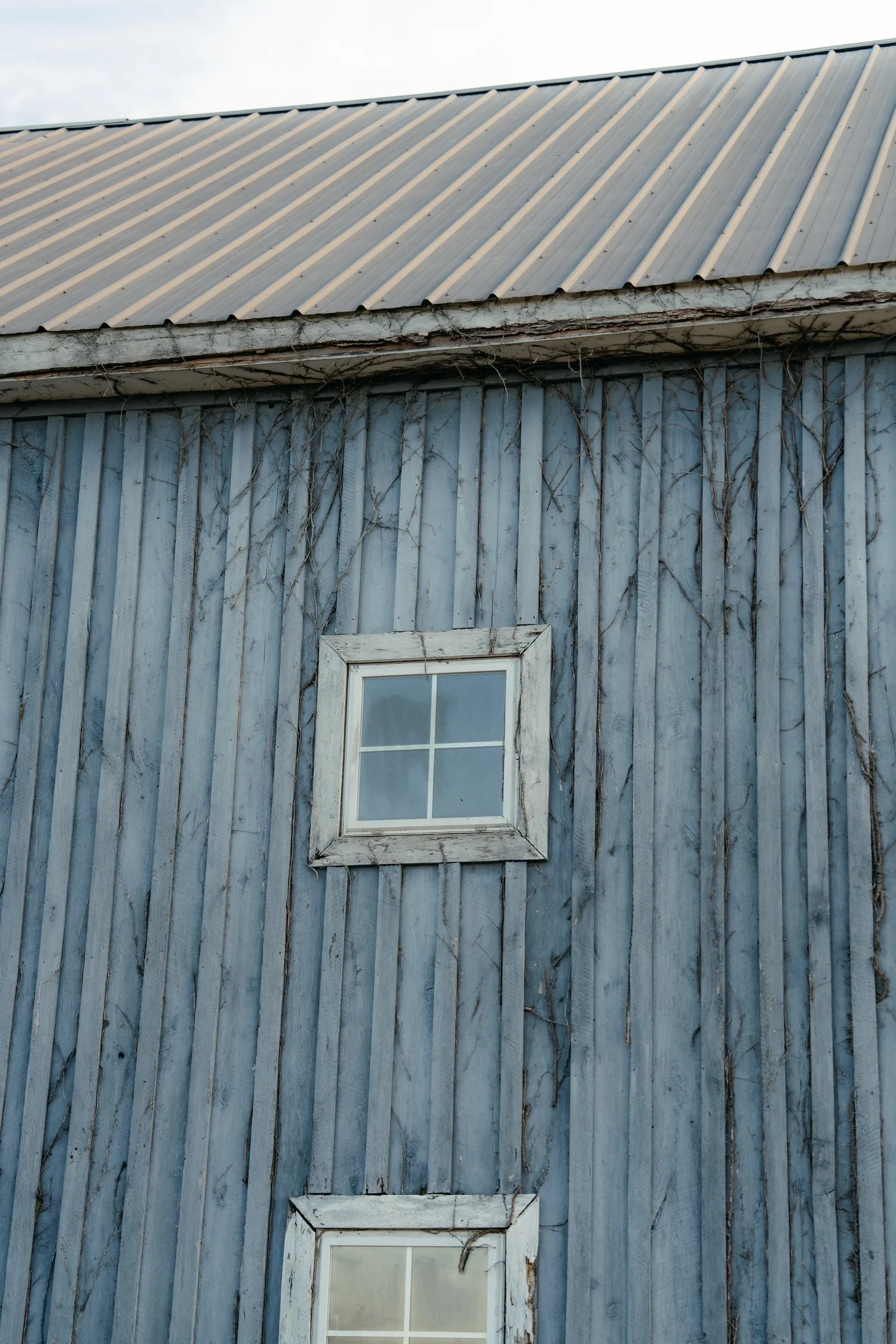 Weathered blue barn siding and a small window