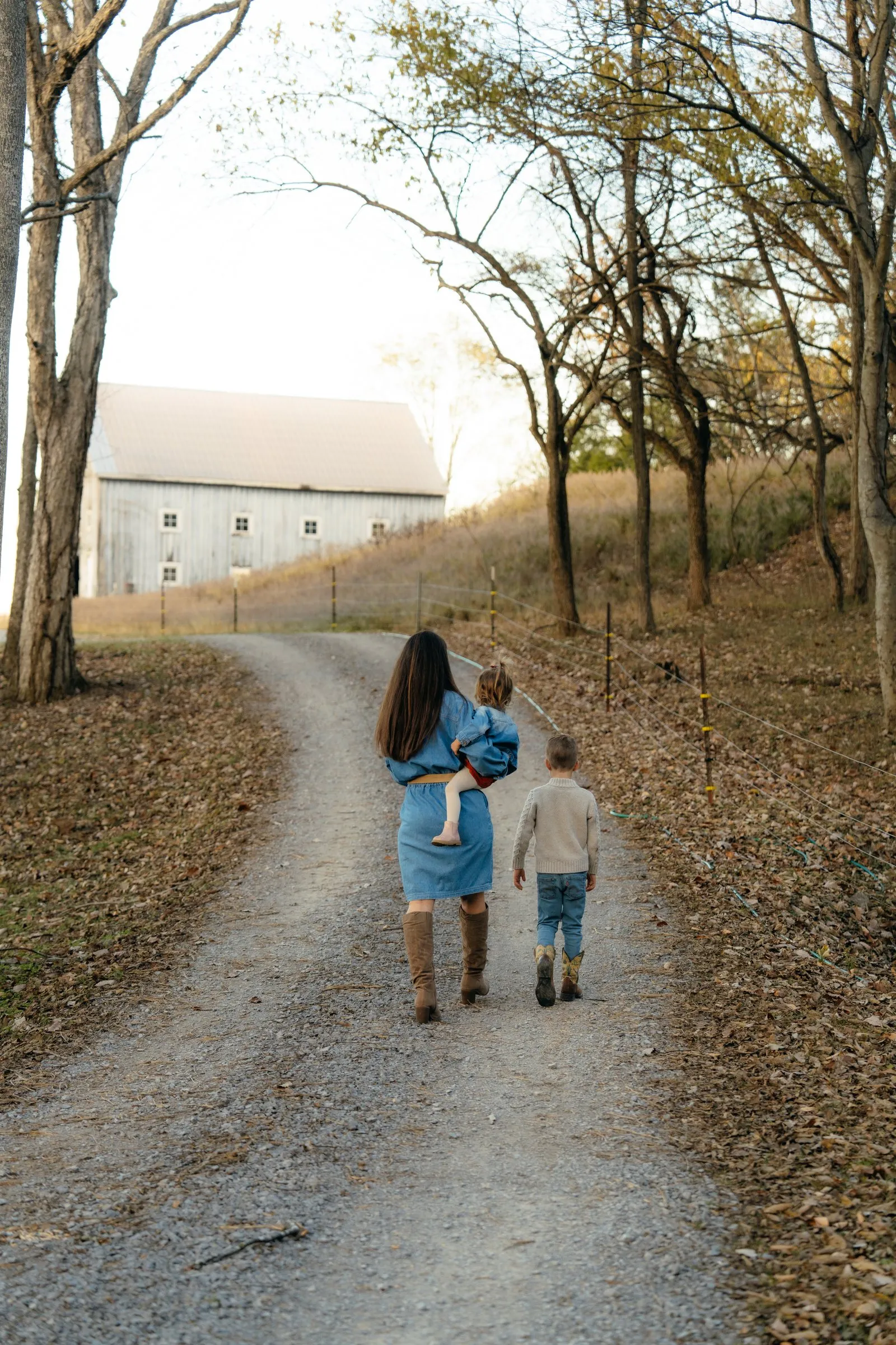 Sarah and the kids walk down the gravel lane toward the white barn