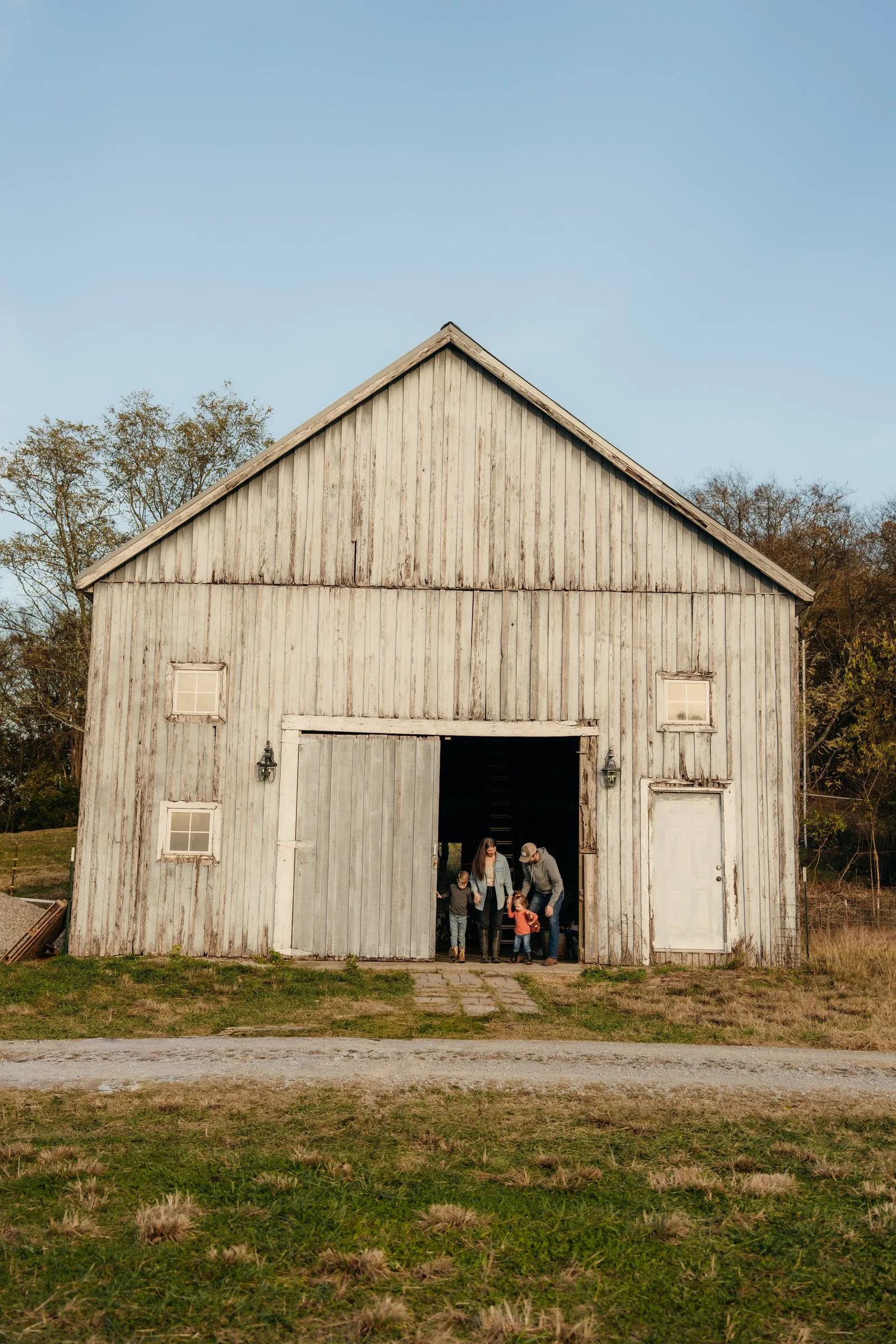 The weathered white barn under a blue sky